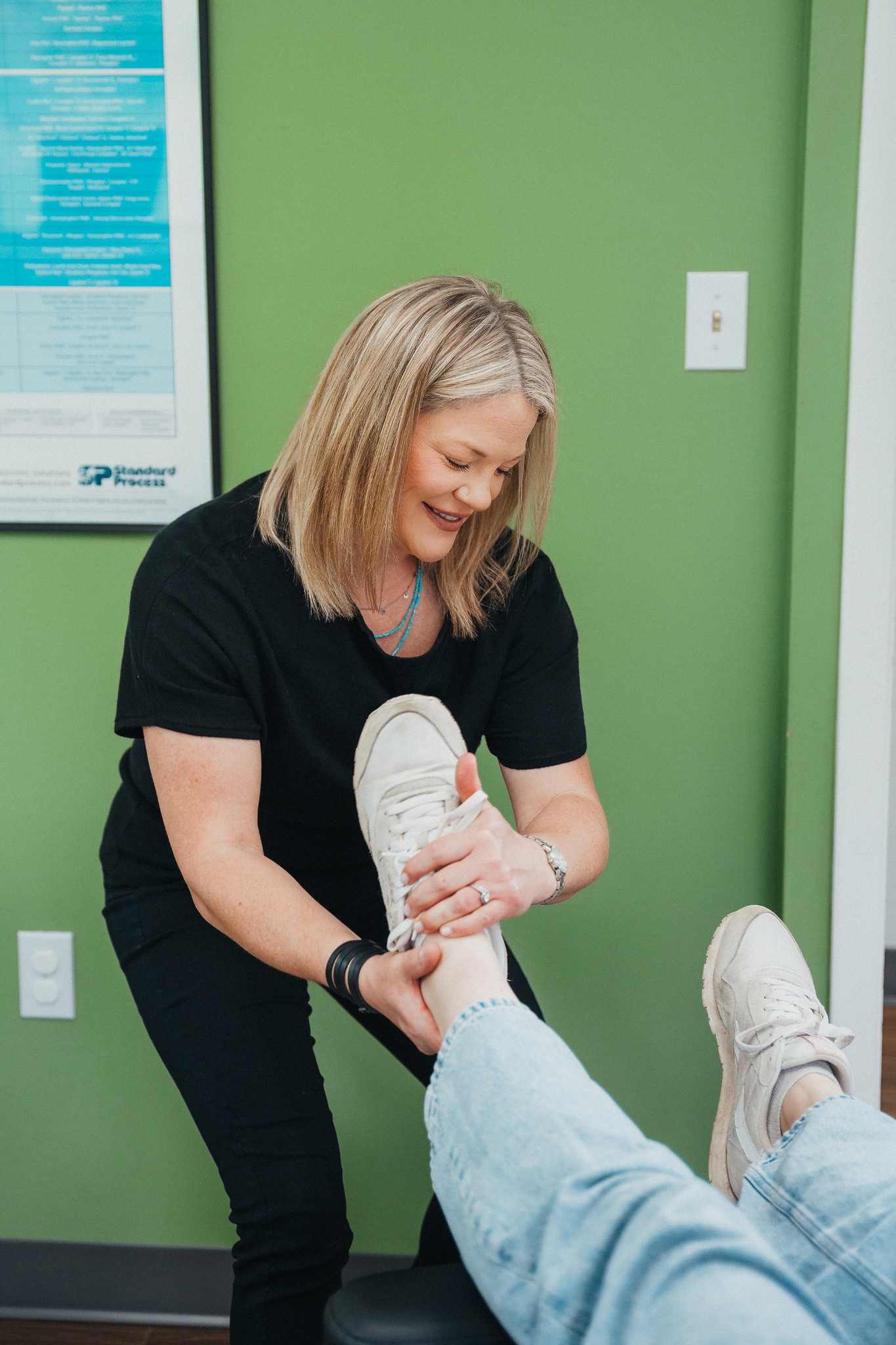 Chiropractor demonstrating a leg and mobility treatment